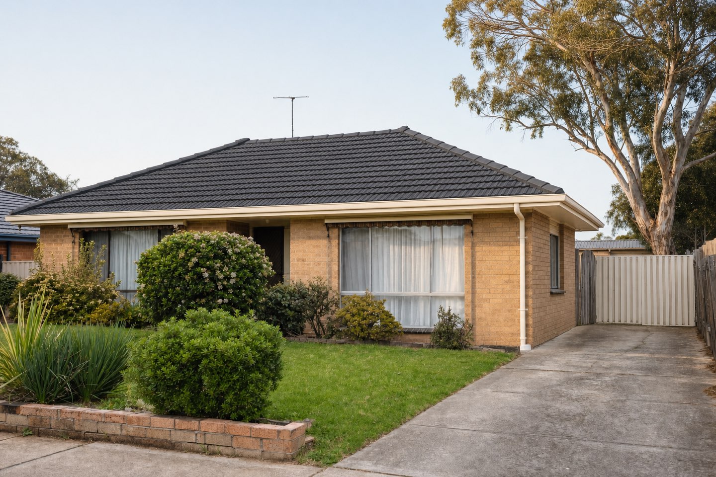 The same home after restoration, roof recoated in deep grey with clean ridge lines