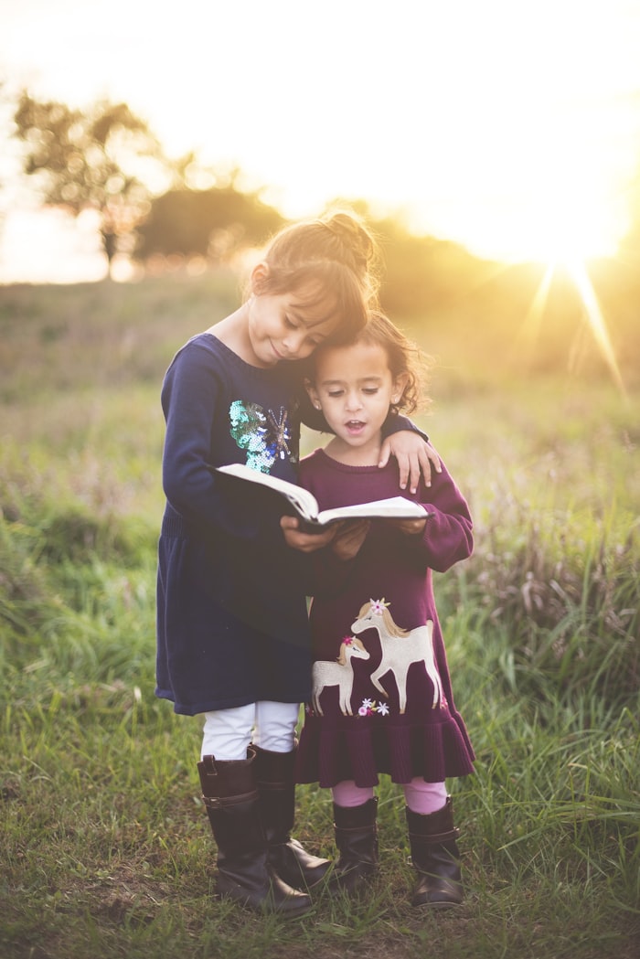 Two children reading together in golden light